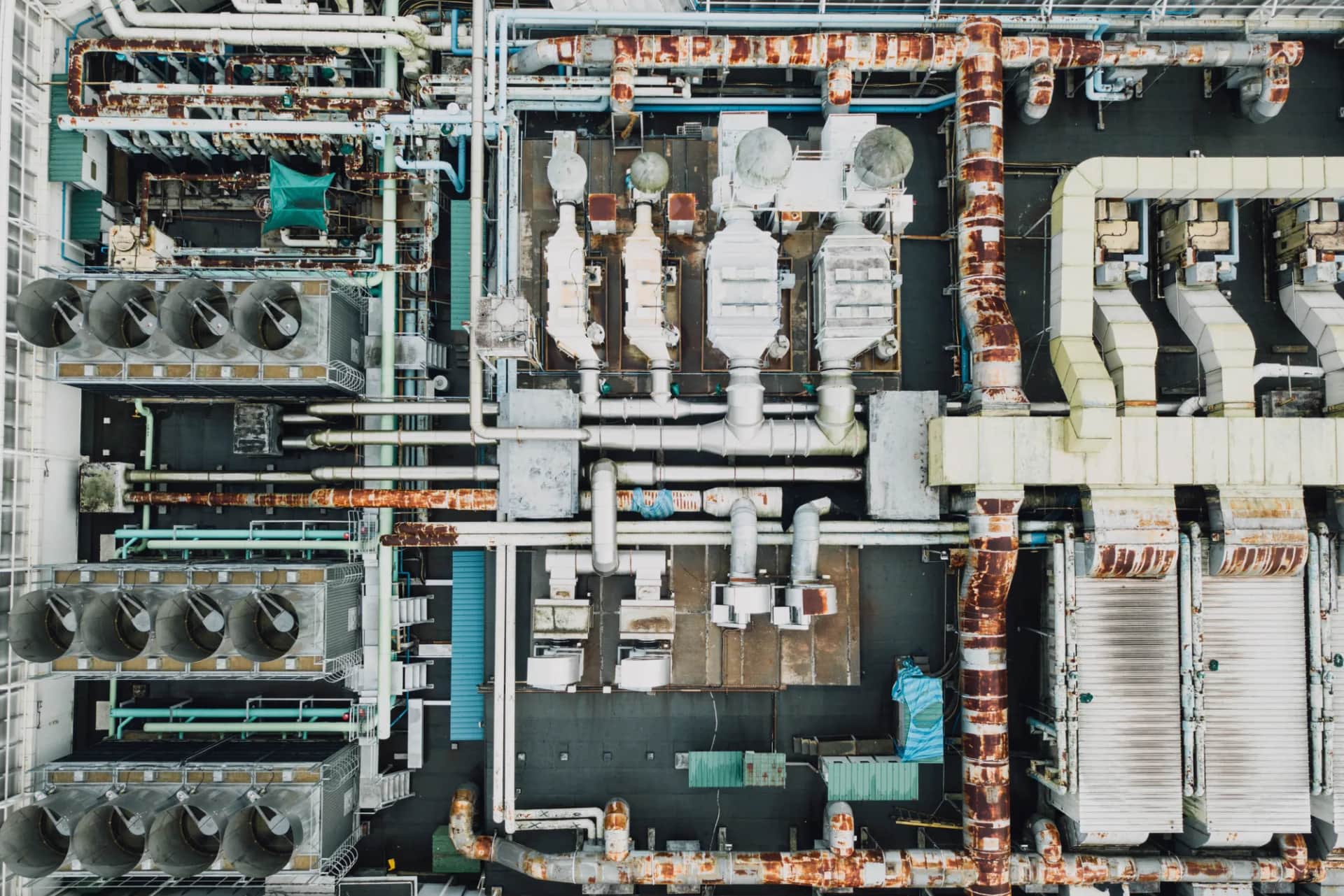 An industrial plant seen straight down from above, a grid of pipework, ducts and cooling units