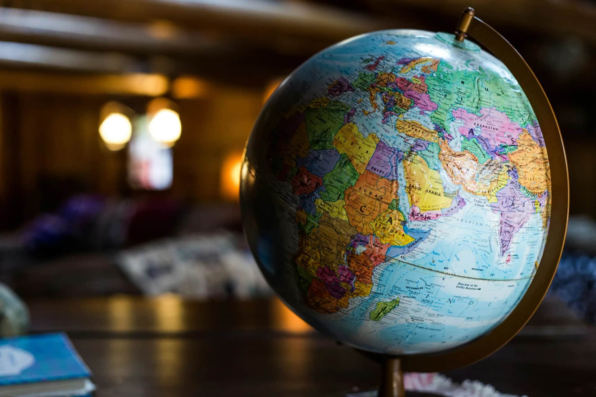 How do you re-engage employees globally through CSR and development?. A desk globe turned to Africa and Asia in a wood-panelled room
