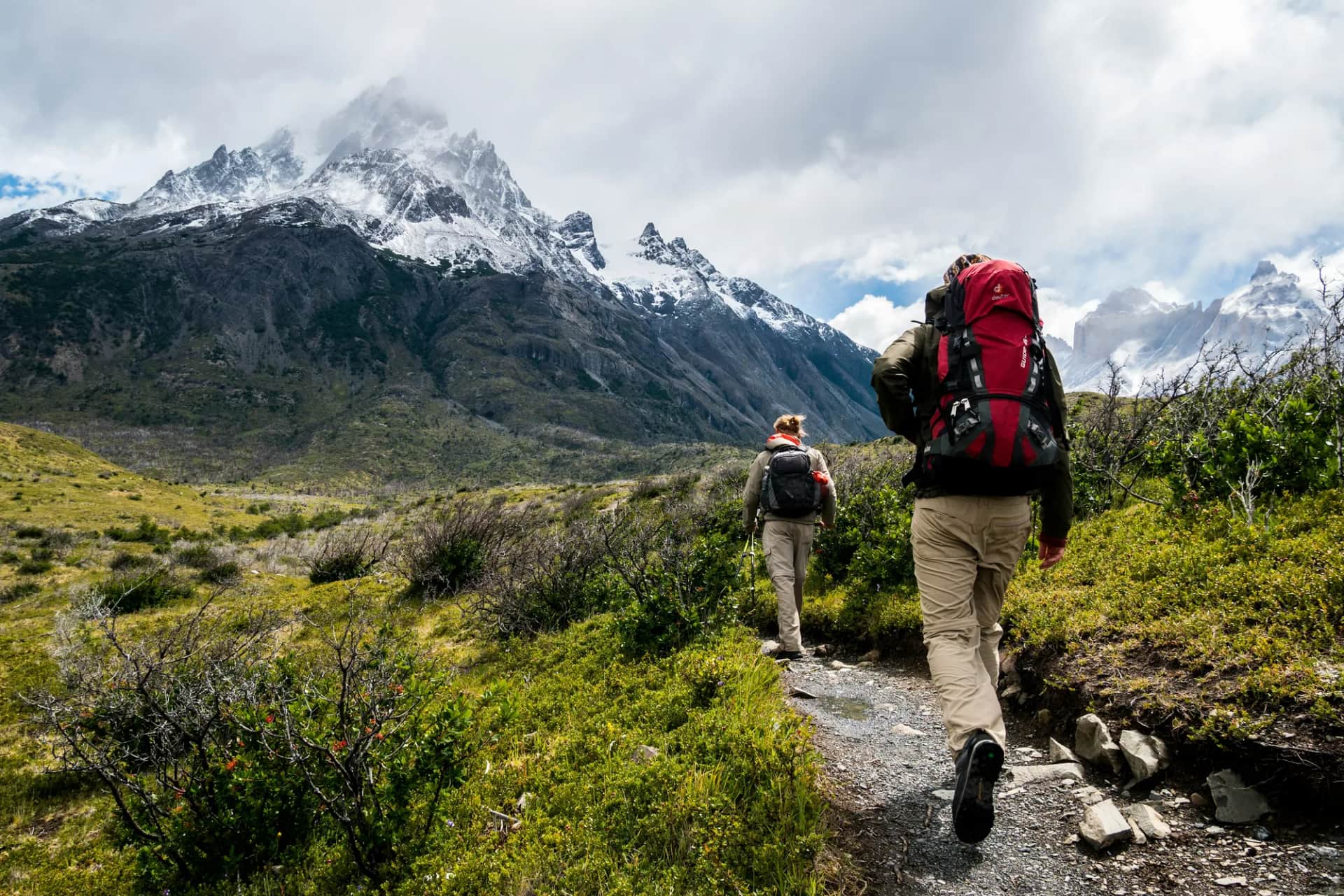How do you align leadership behaviour with strategy execution across locations?. Two walkers with rucksacks on a trail heading towards snow-capped peaks