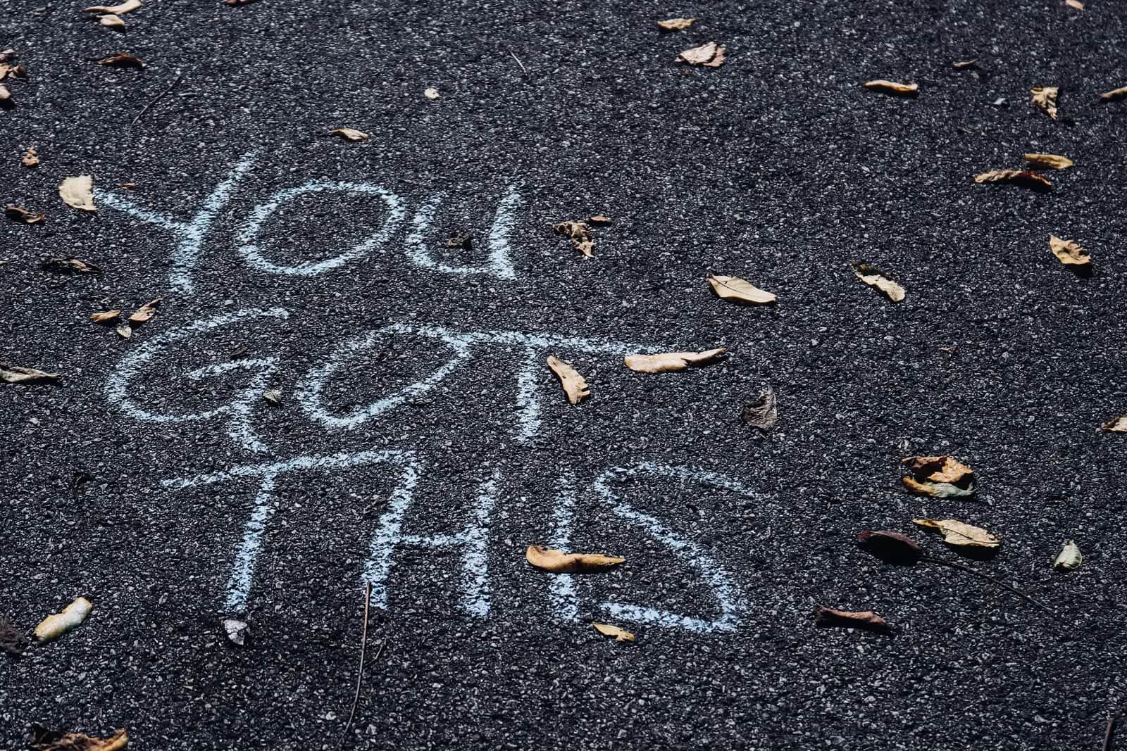 The words you got this chalked on tarmac among fallen leaves