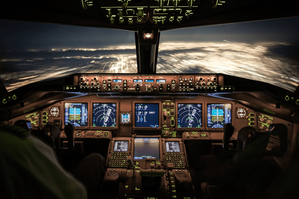 Night-time aircraft cockpit with two pilots working the instruments